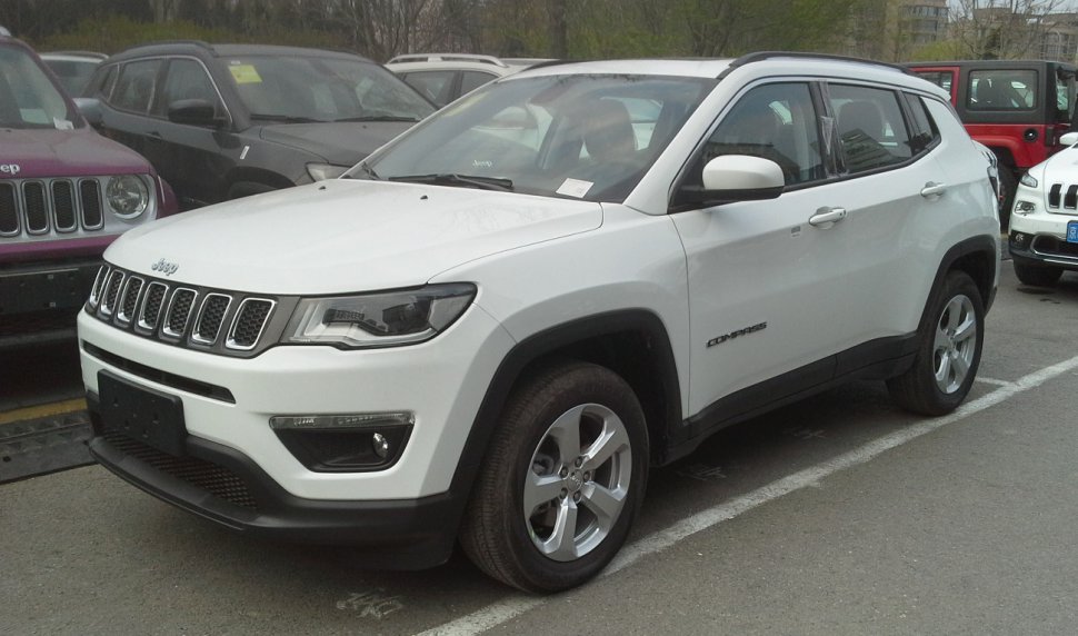 Front side view of white SUV with distinctive grille and headlights