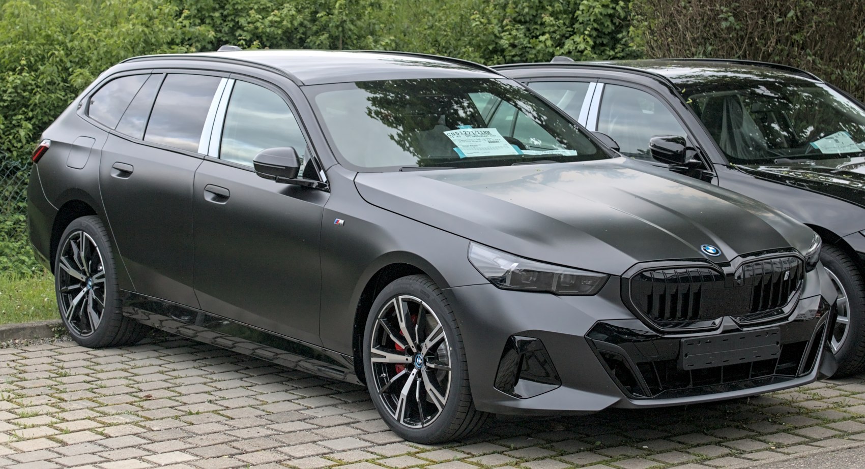 Matte black station wagon with sporty front grille and wheels