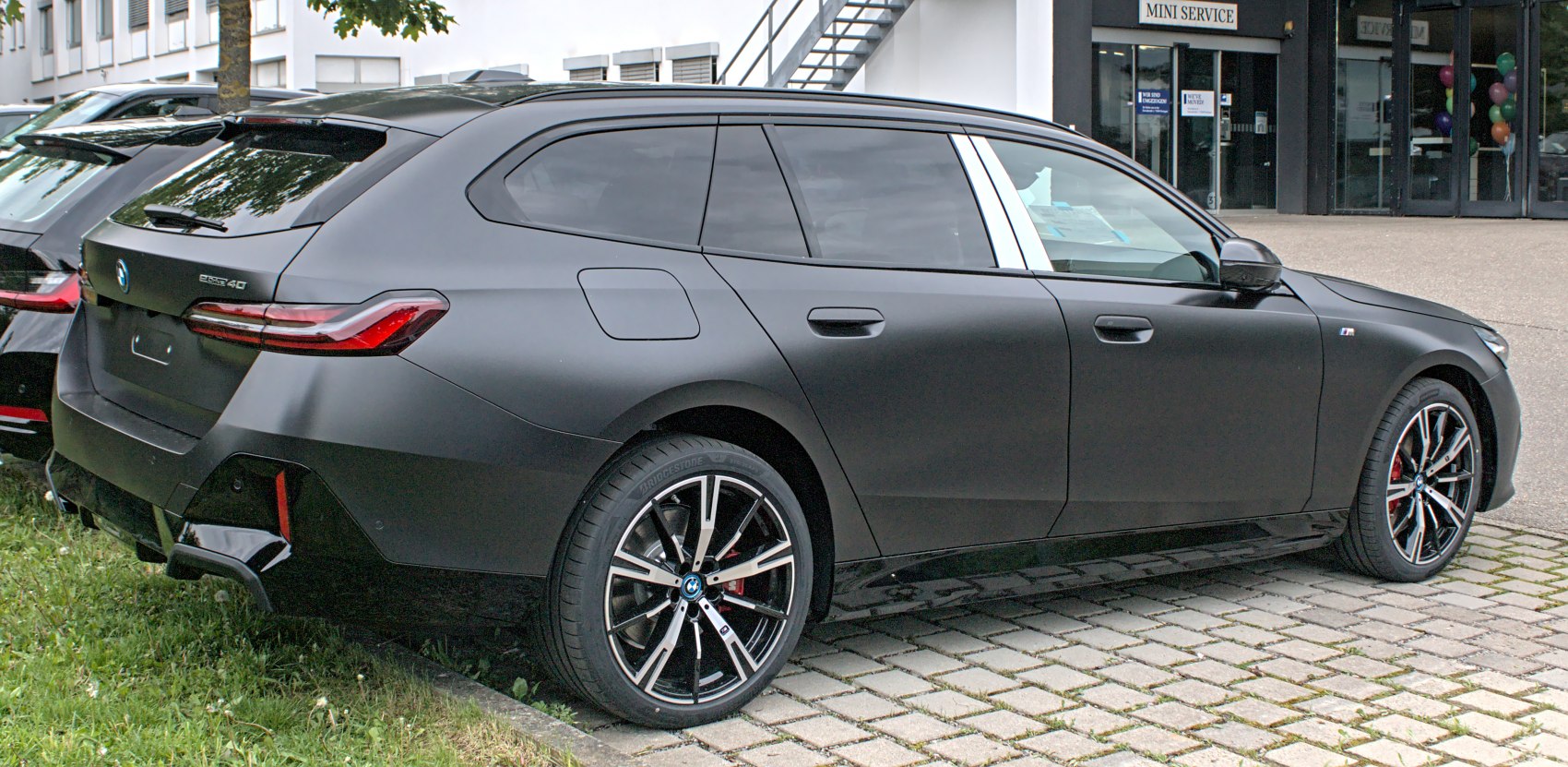 Side and rear view of a black electric touring wagon with alloy wheels