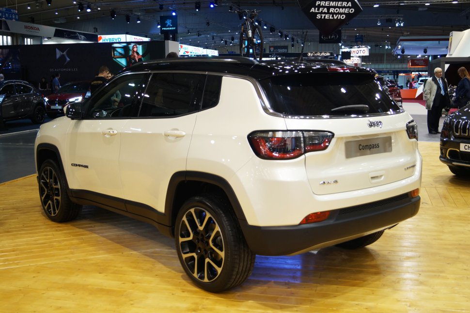 Rear side view of white SUV with black roof and distinct tail lights