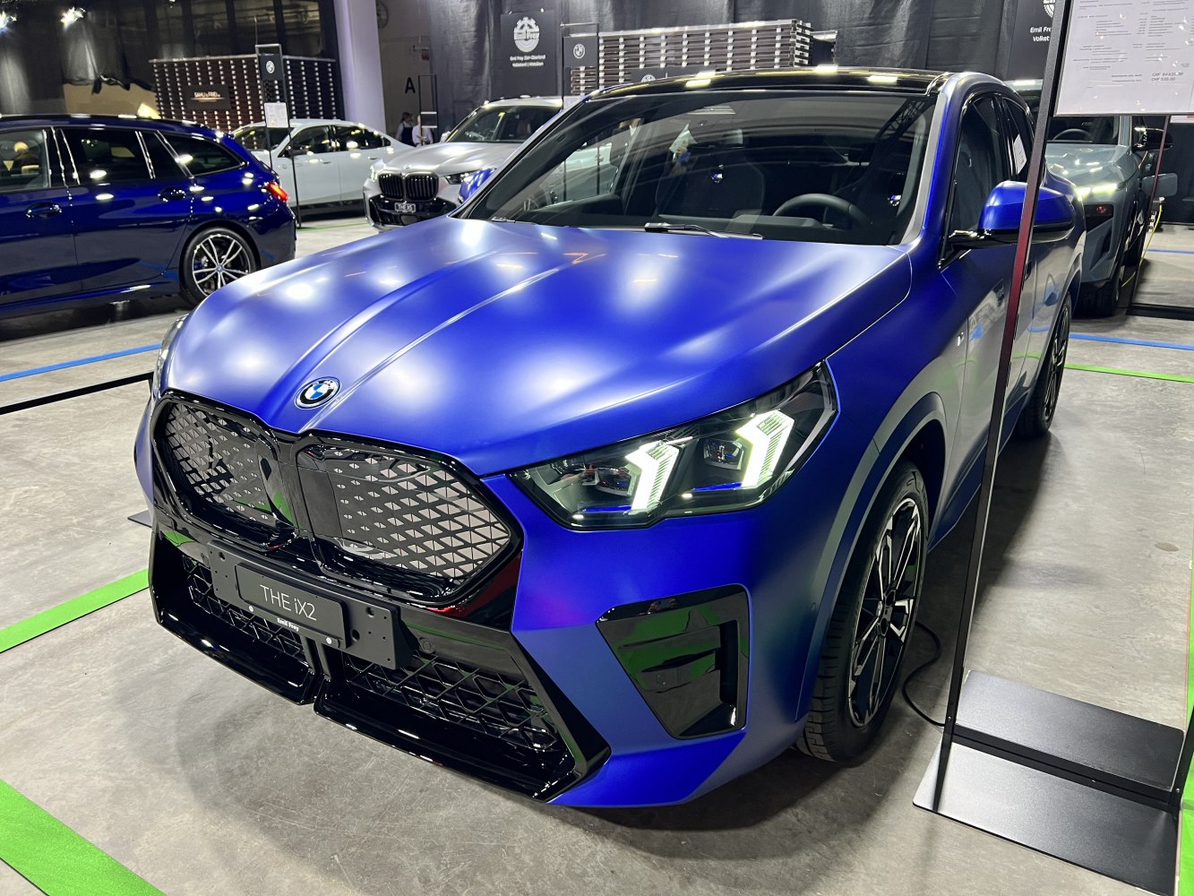Front view with illuminated LED headlights and kidney grille in matte blue finish.