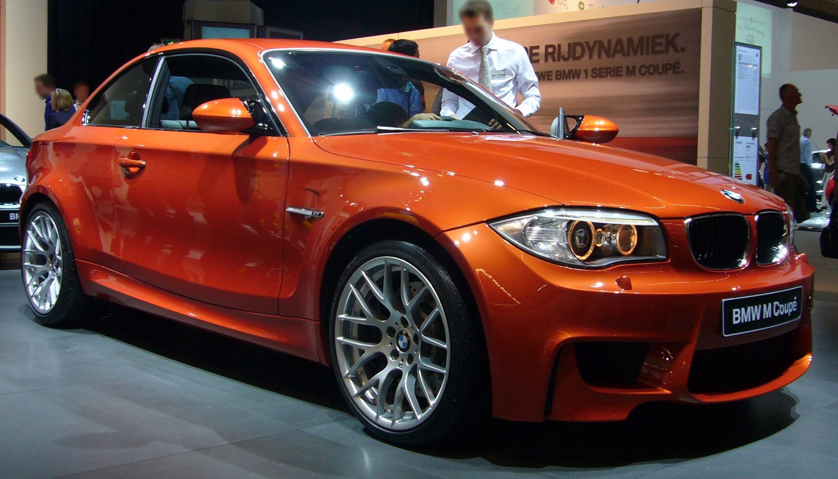 Orange coupe with distinctive front headlights and multi-spoke alloy wheels