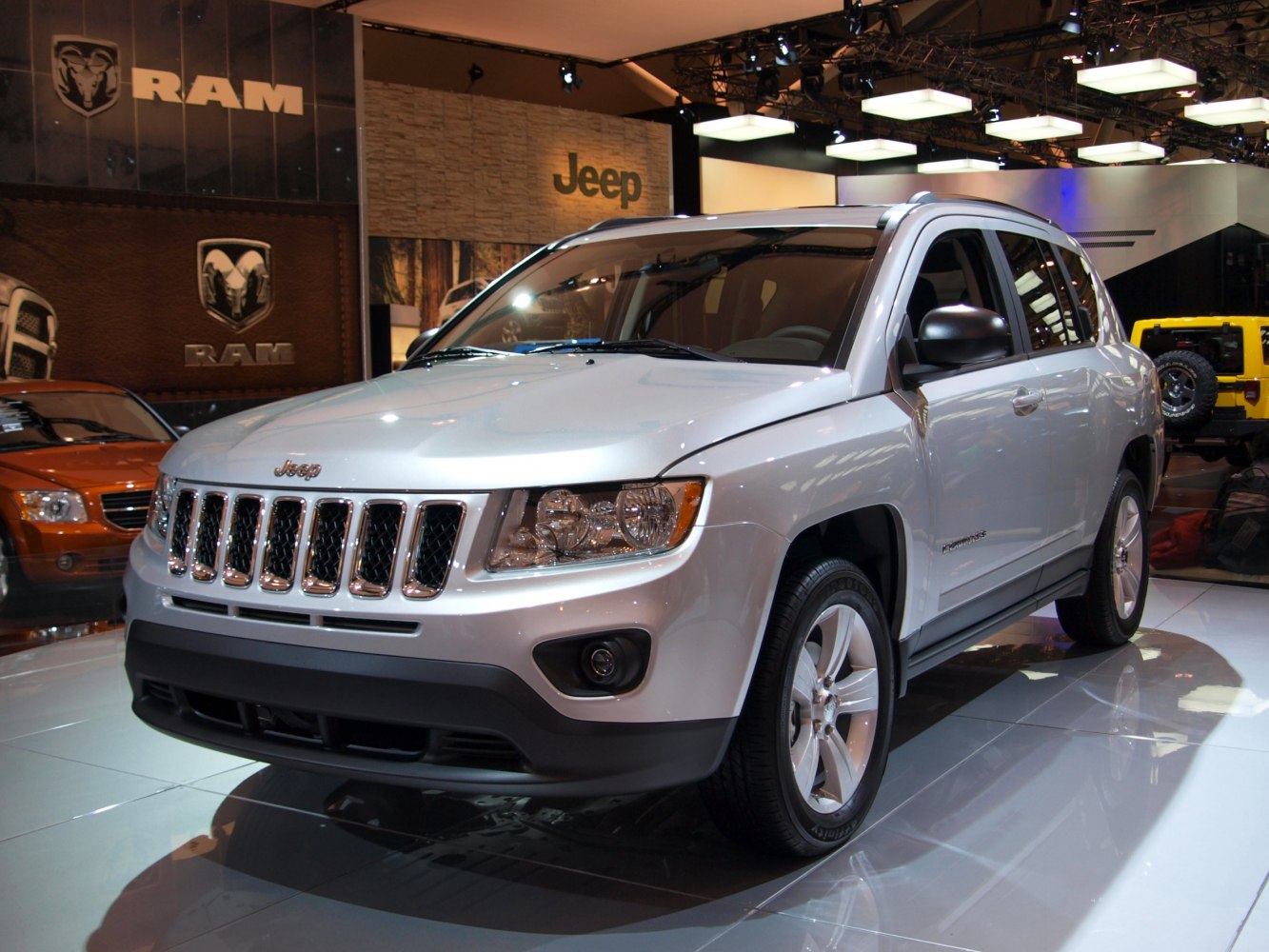 Silver SUV front-side view with Jeep's signature grille and headlights
