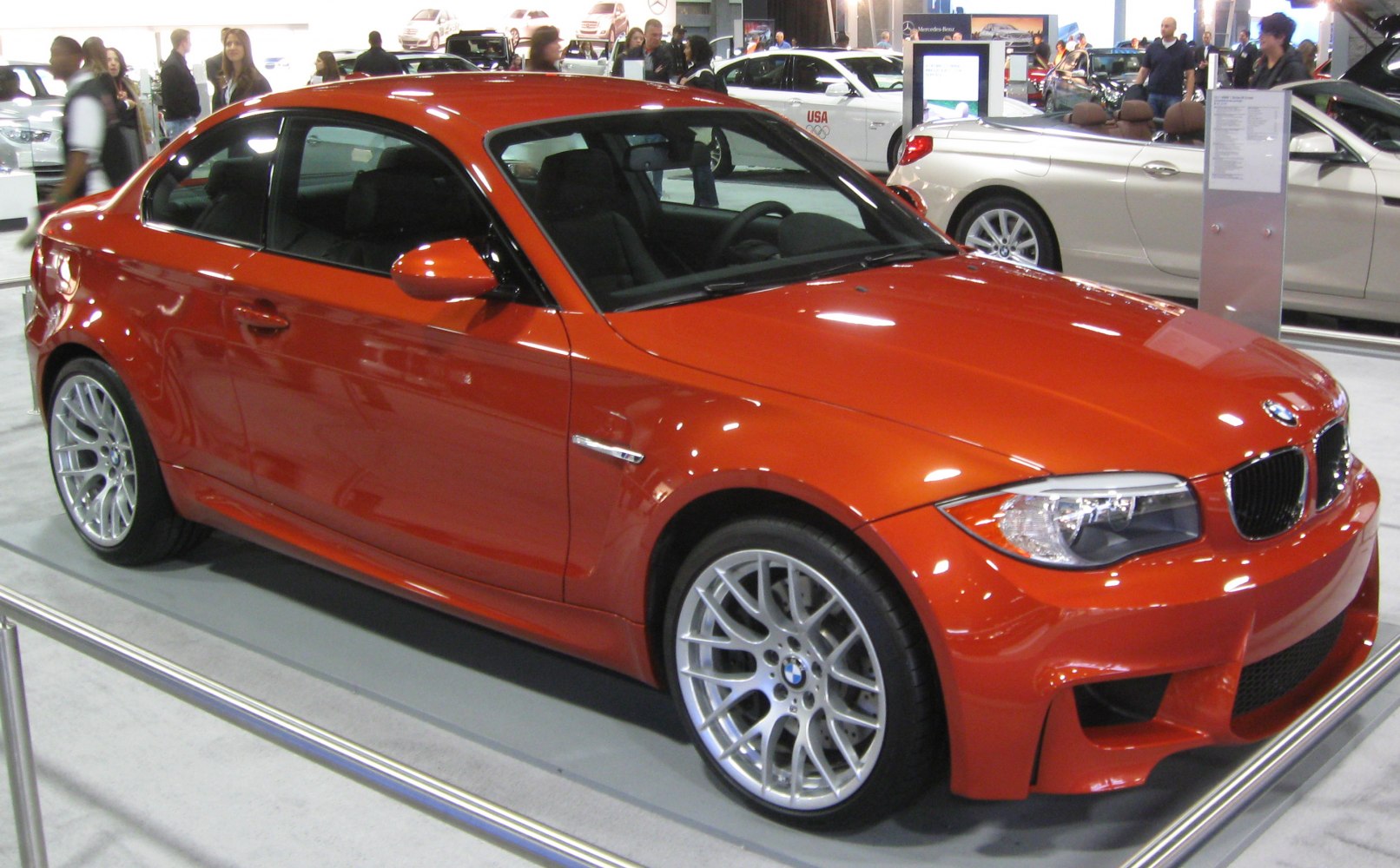 Orange sporty coupe with aggressive front and intricate alloy wheels