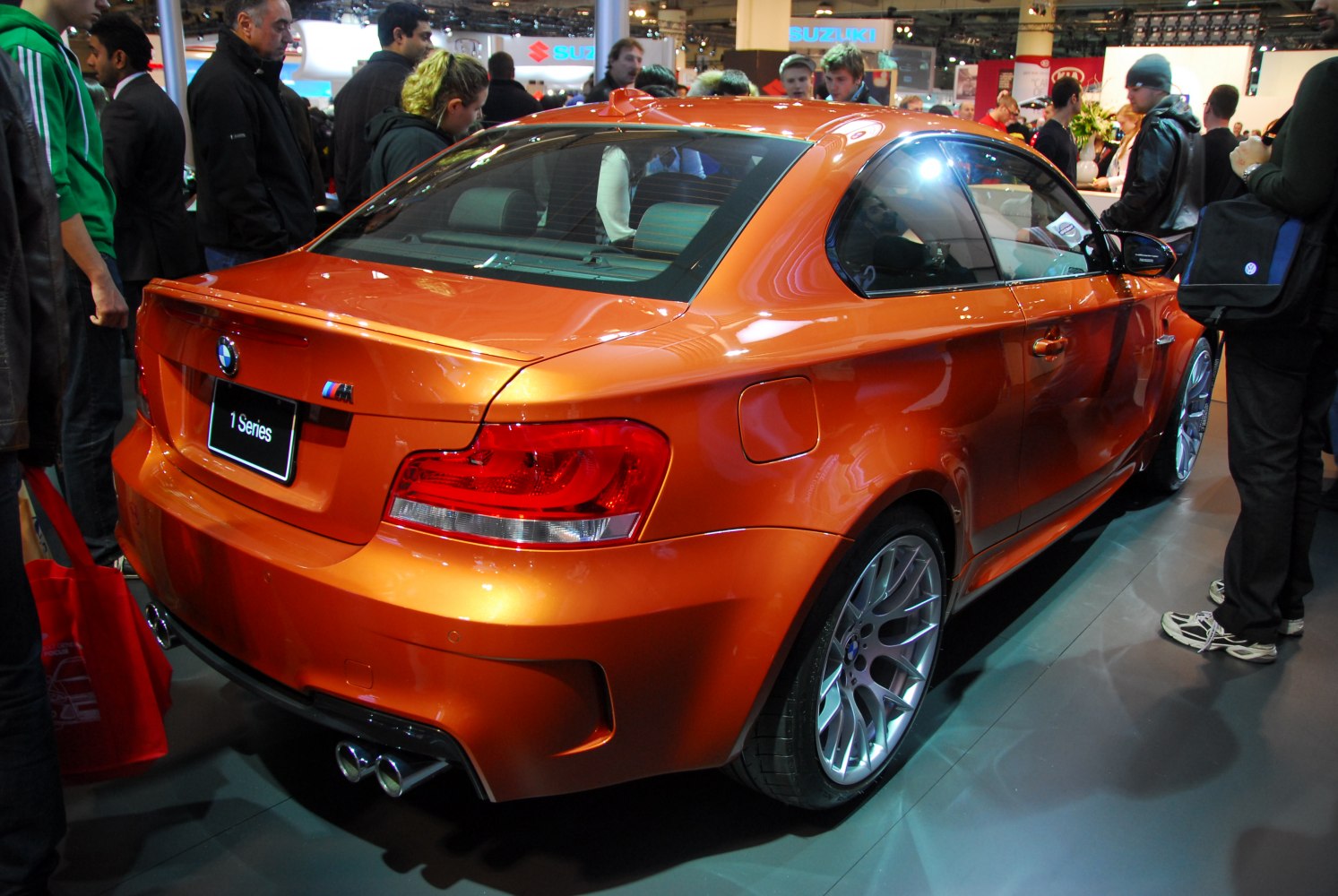 Rear profile of orange sporty coupe with quad exhausts and distinctive alloy wheels