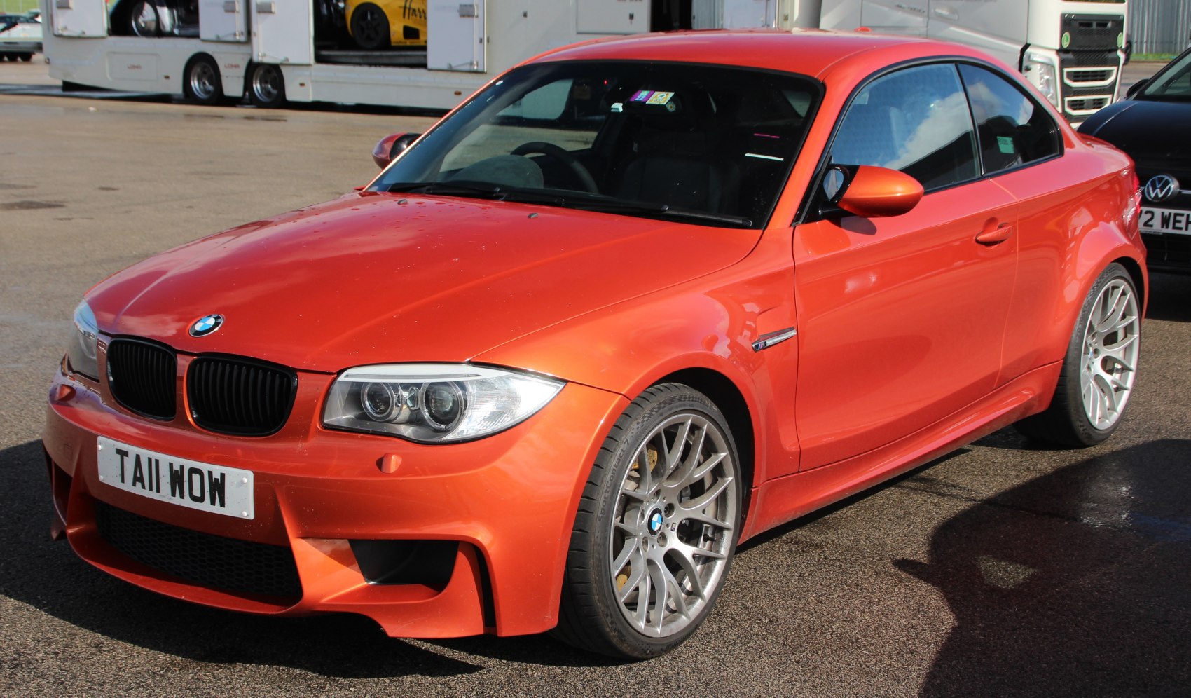 Front side view of sporty orange coupe with distinctive grille and wheels