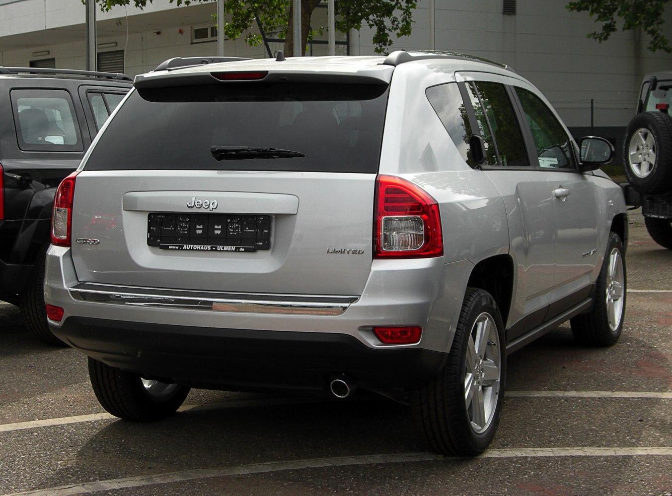 Silver SUV rear with taillights, tinted window, and single exhaust.
