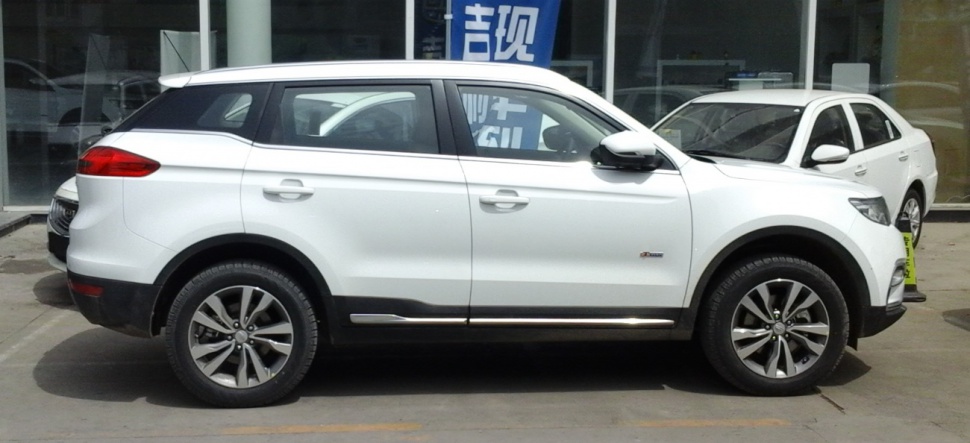 Side profile of white SUV with alloy wheels in parking lot