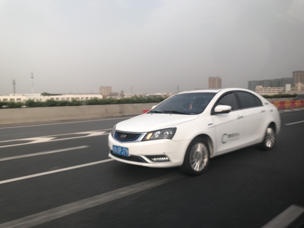 White electric sedan front side driving on road