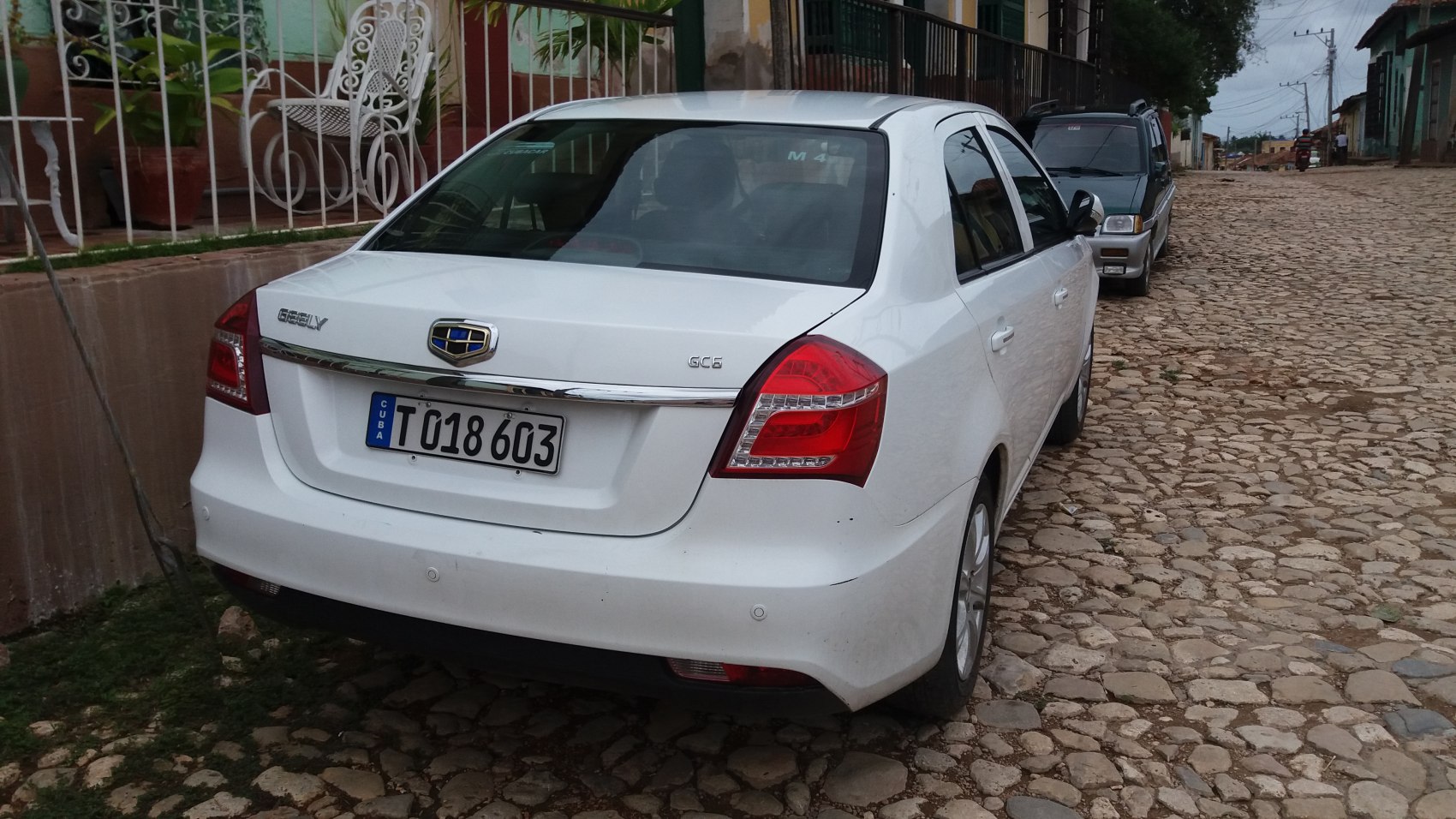 Rear view of white sedan with taillights and chrome trim