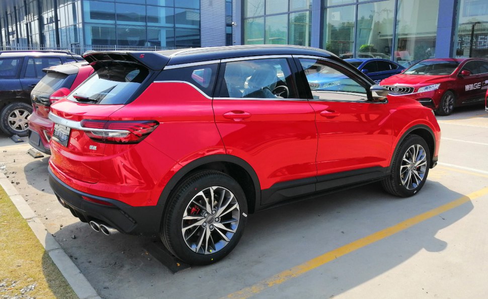 Red compact SUV rear side with black roof and dual exhaust