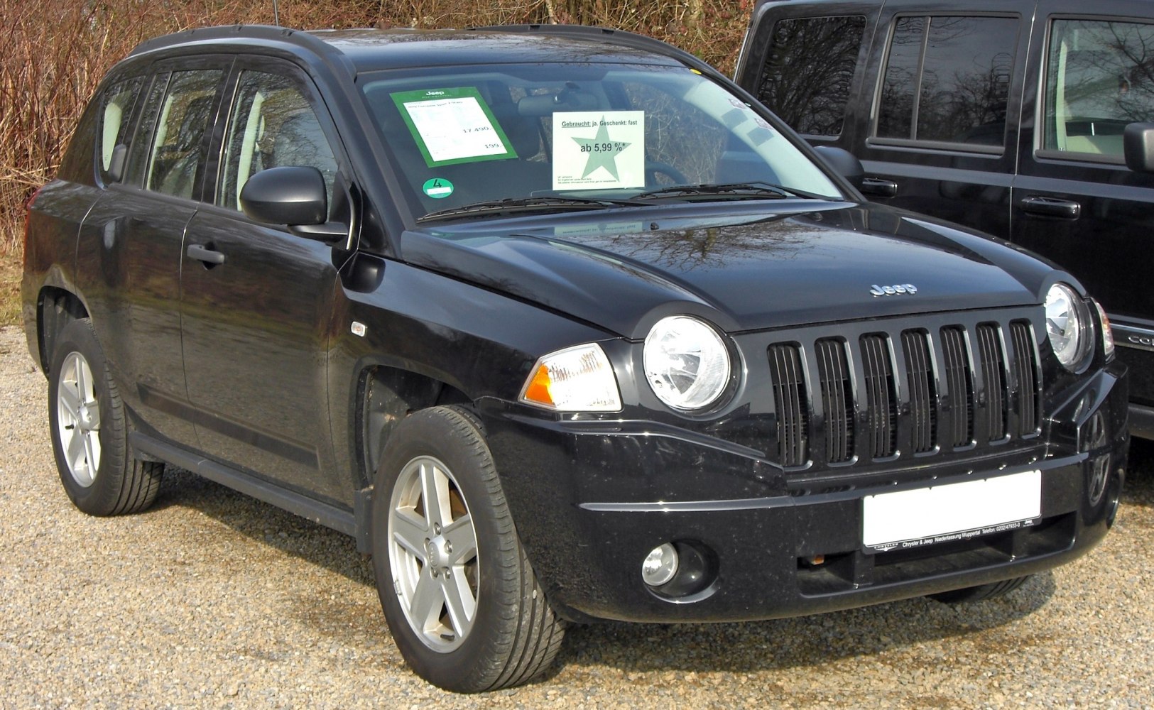 Front view showing round headlights and vertical grille