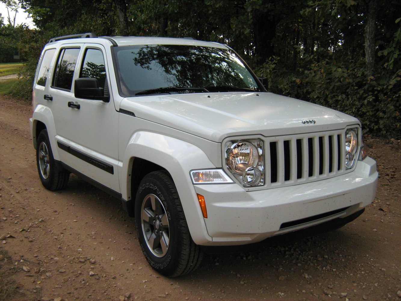 Front three-quarter view of rugged white SUV on dirt road