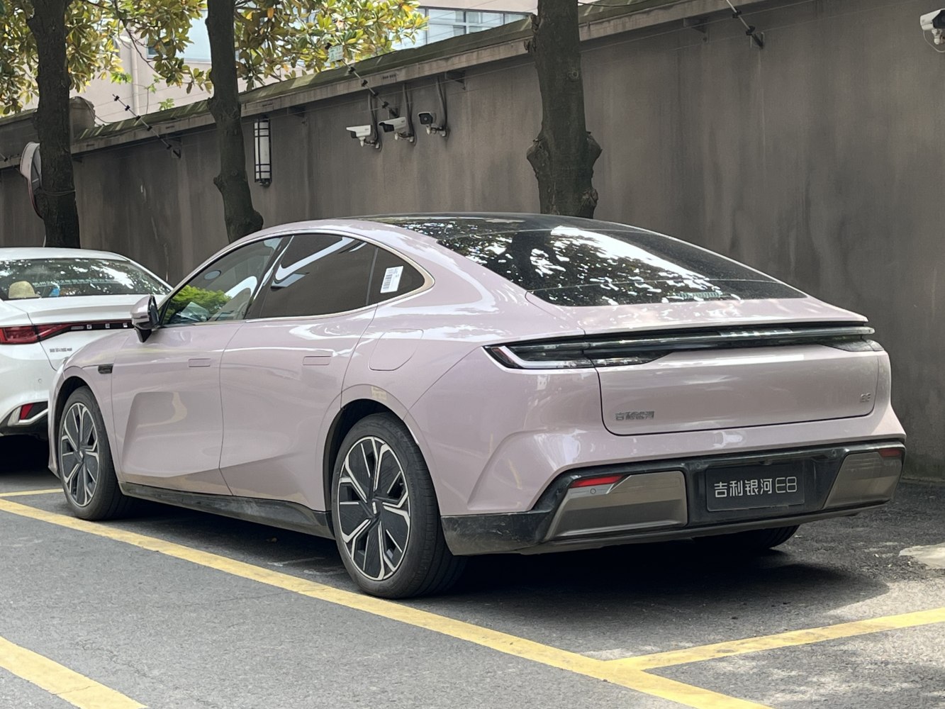 Sleek modern electric sedan rear-side view with LED taillight bar and flush door handles