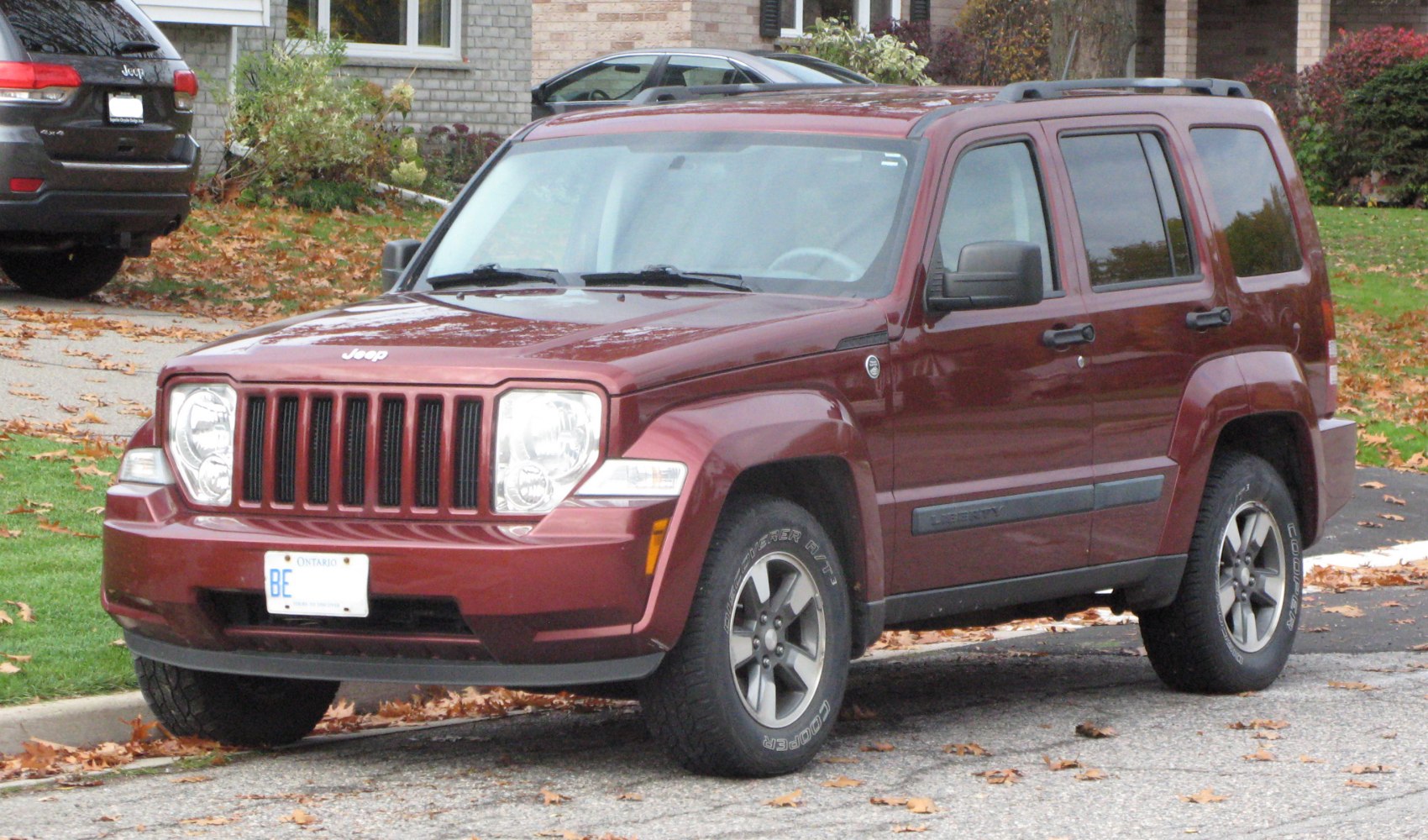Front side view of red SUV with distinctive grille and rugged design