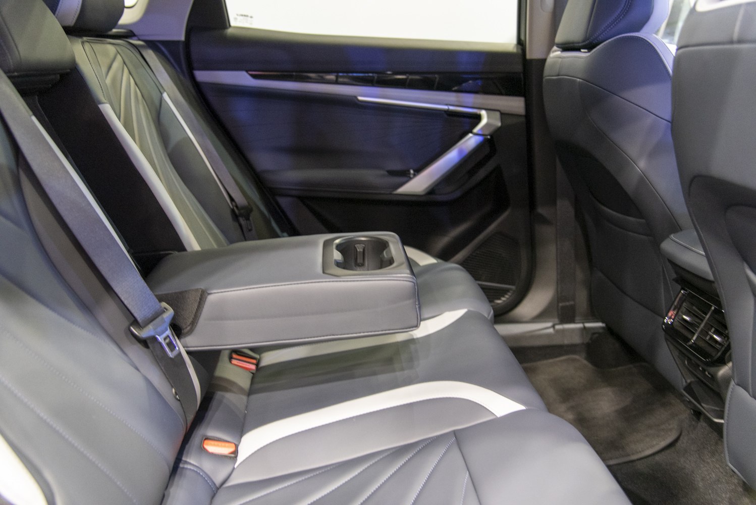 Rear seat with leather upholstery, center armrest, and cup holder
