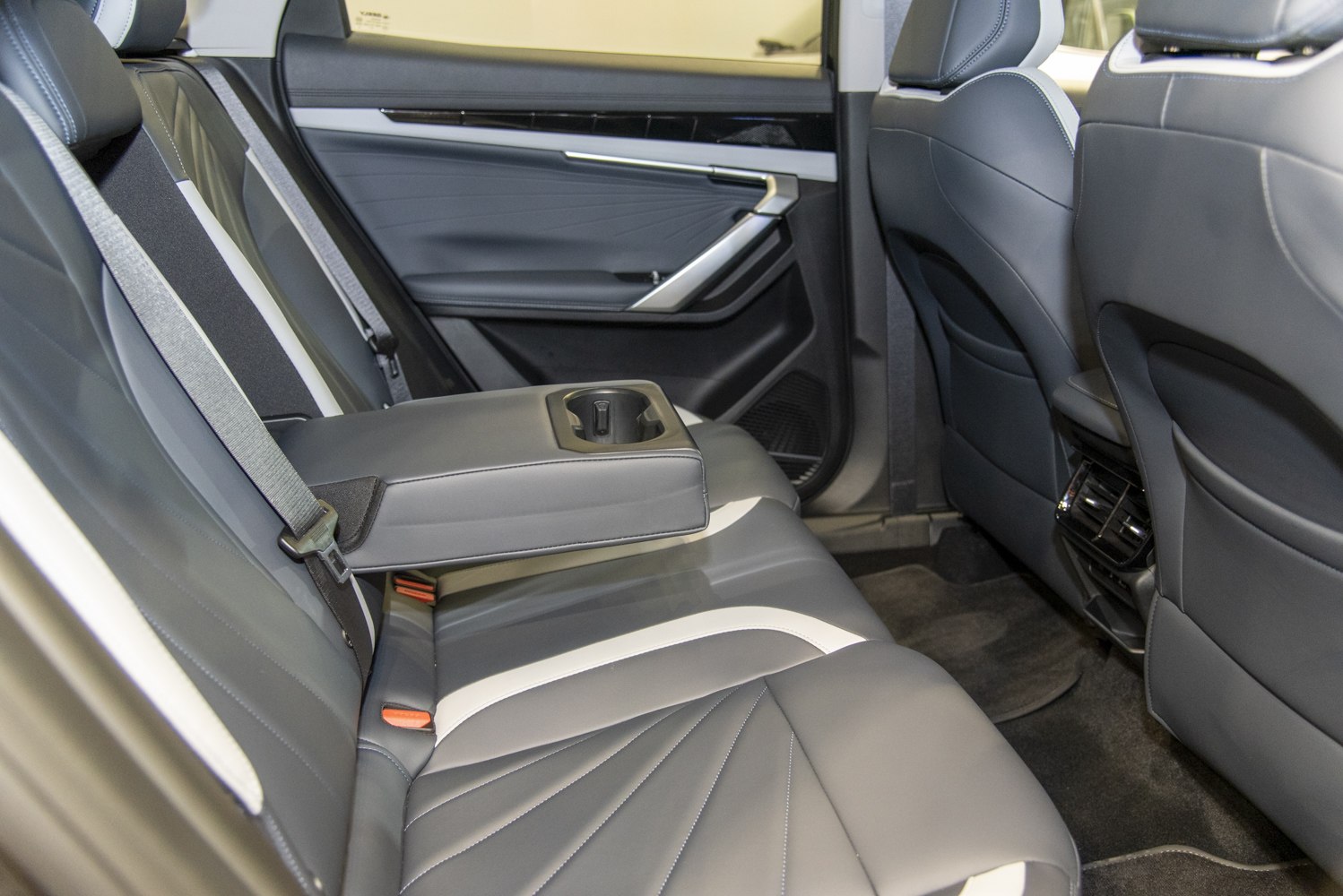 Rear seat leather upholstery with fold-down armrest and cup holder