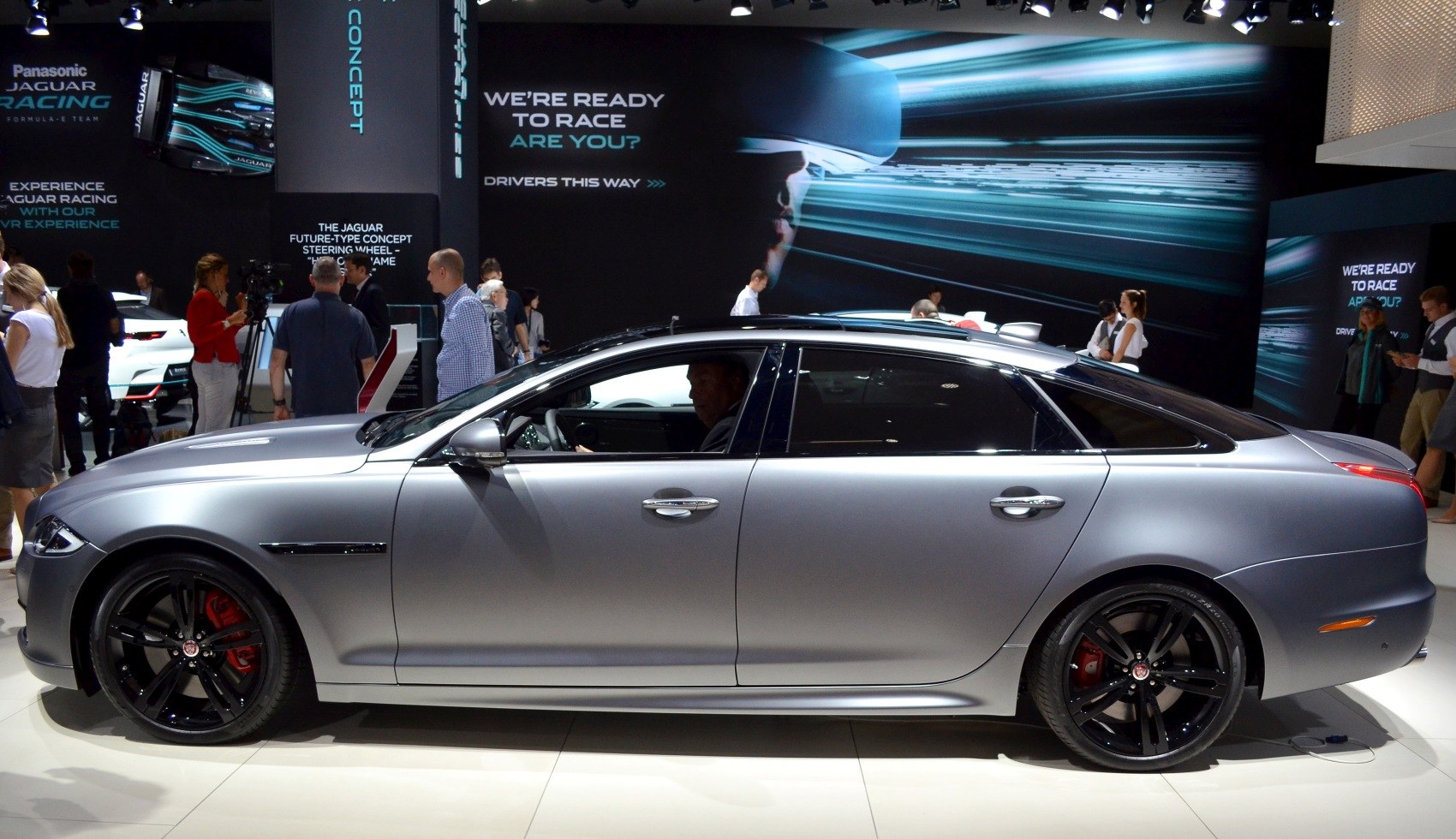 Silver luxury sedan with sleek black rims and red brake calipers side profile