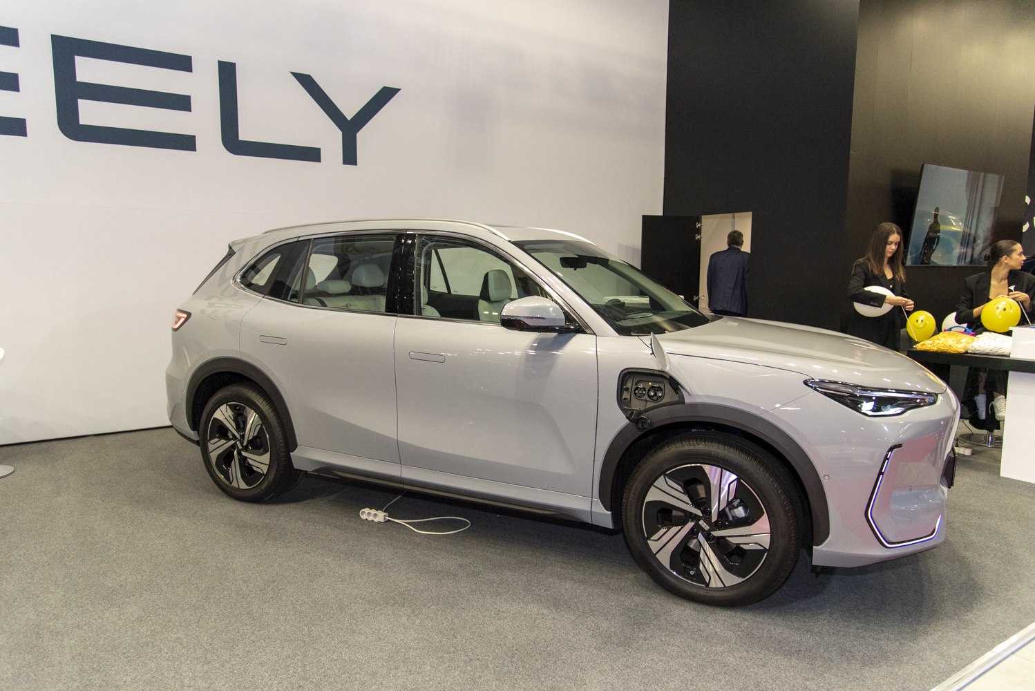 Electric SUV at charging port with sleek modern design and distinct lighting.