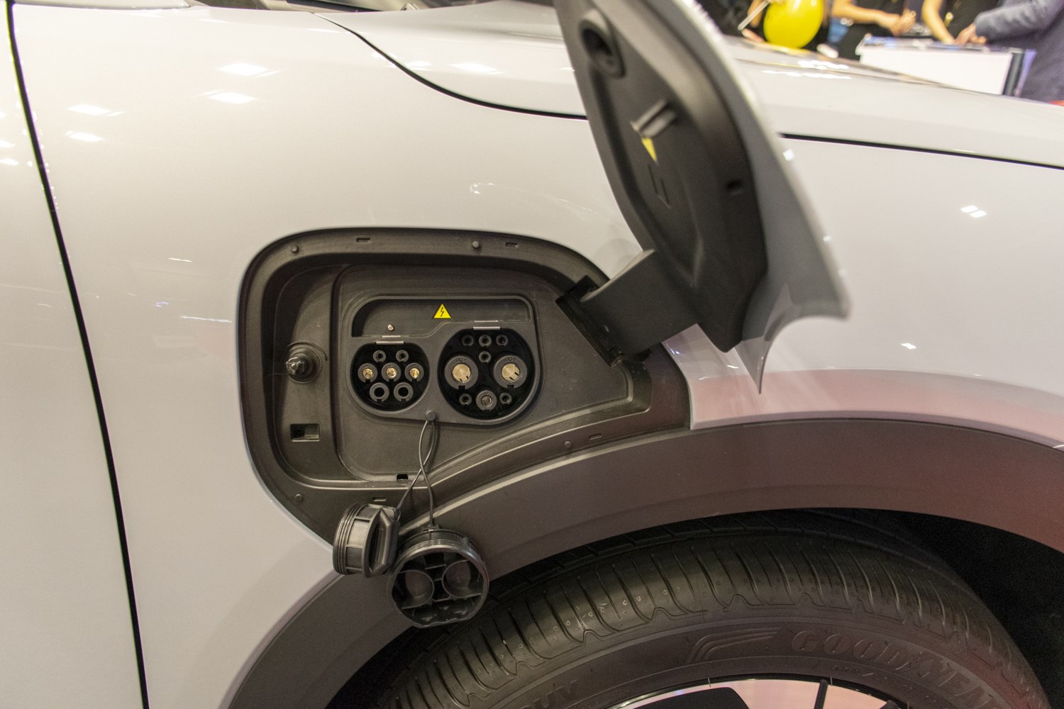 Close-up of EV charging port with connectors on vehicle rear side.