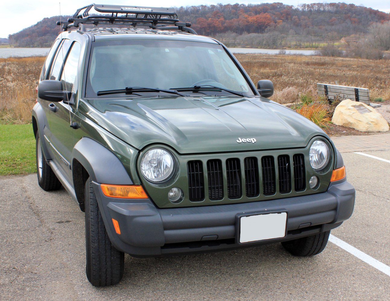 Front view of SUV with round headlights, seven-slot grille, and roof rack