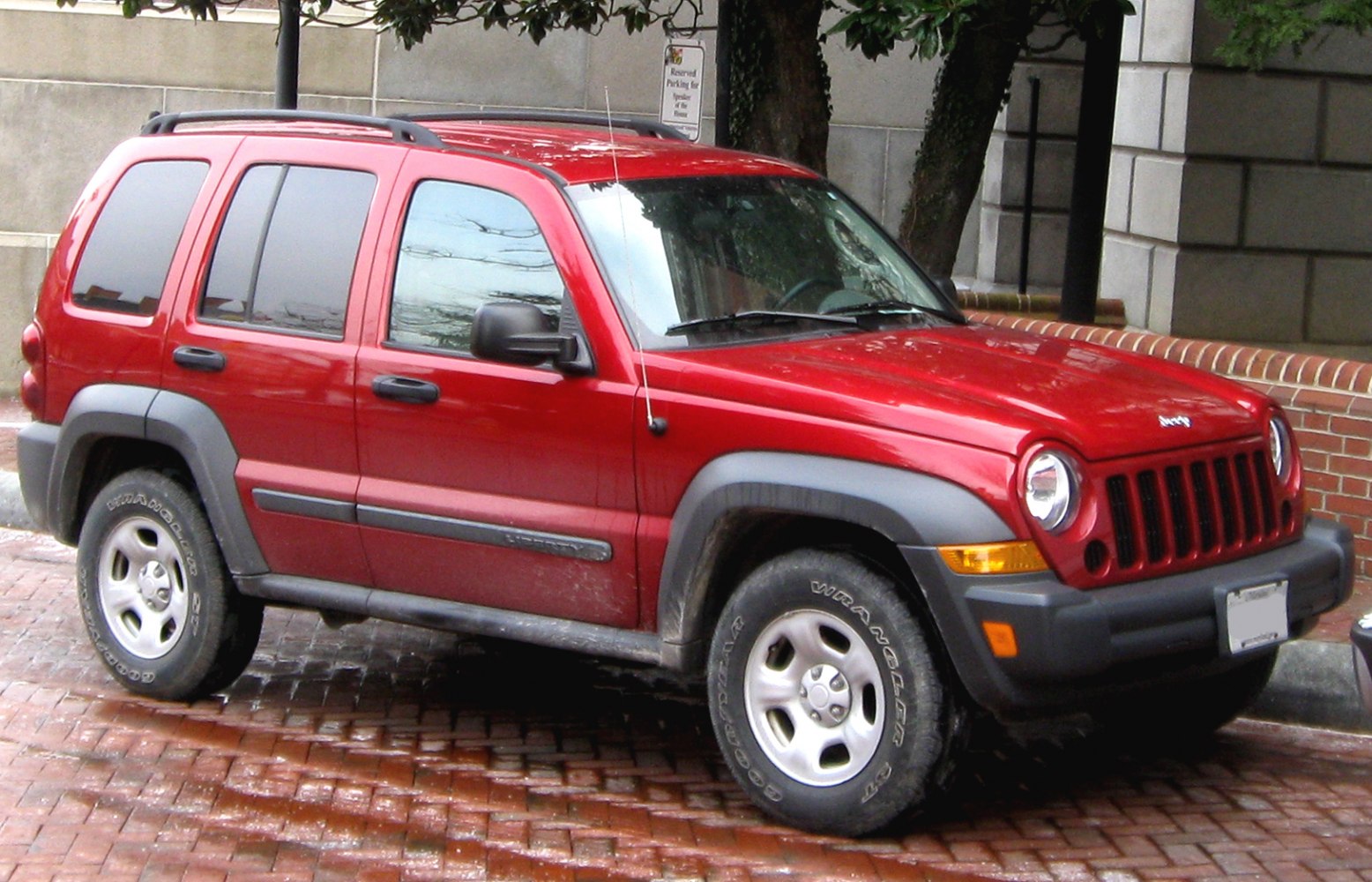 Red SUV with round headlights, seven-slot grille, and grey trim.