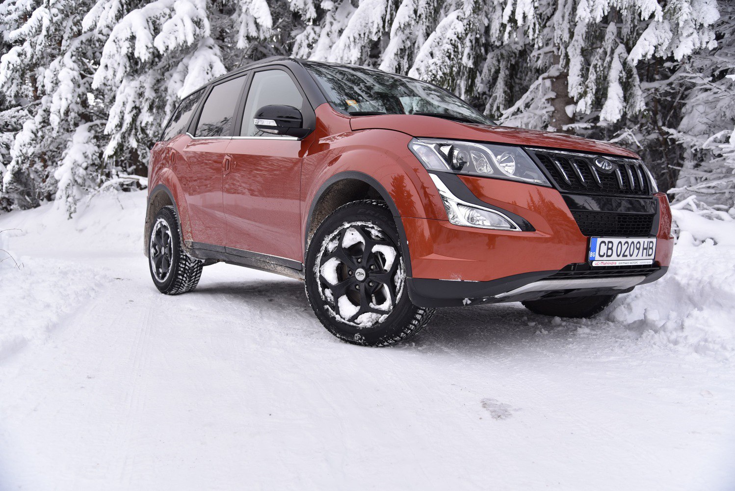 Front-side view of SUV in snowy environment with distinct headlights and grille