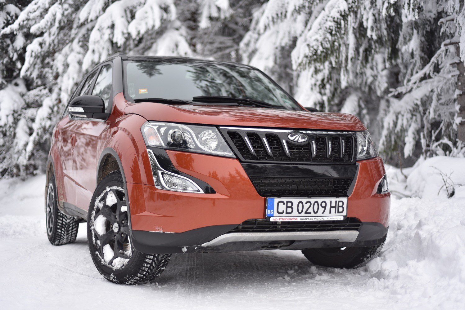 Front view of SUV with distinct grille, headlamps, and winter tires in snow
