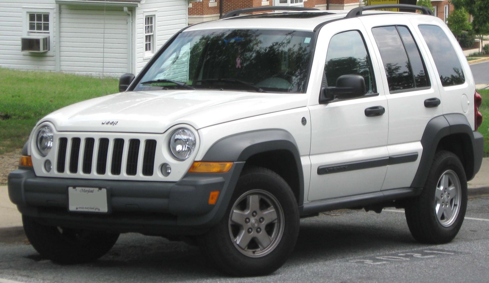 Front side view with round headlights and vertical grille slots.