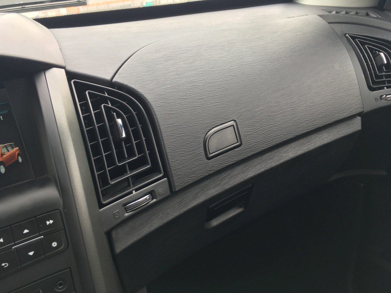 Air vent and glove compartment in textured dashboard interior