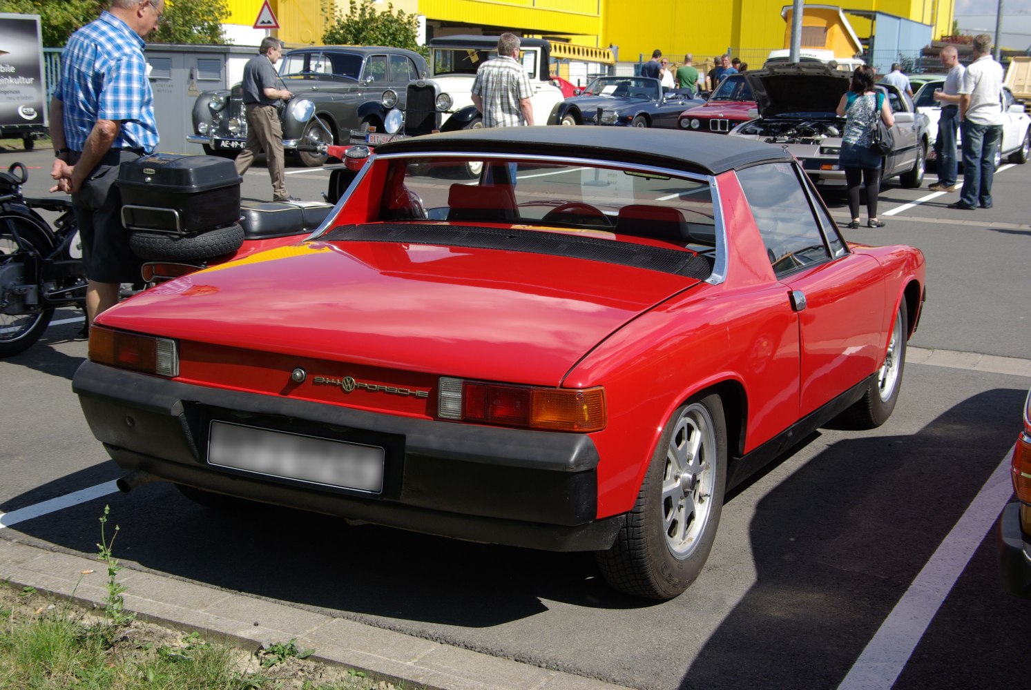 Classic vintage red targa rear view with black bumper and angular design.