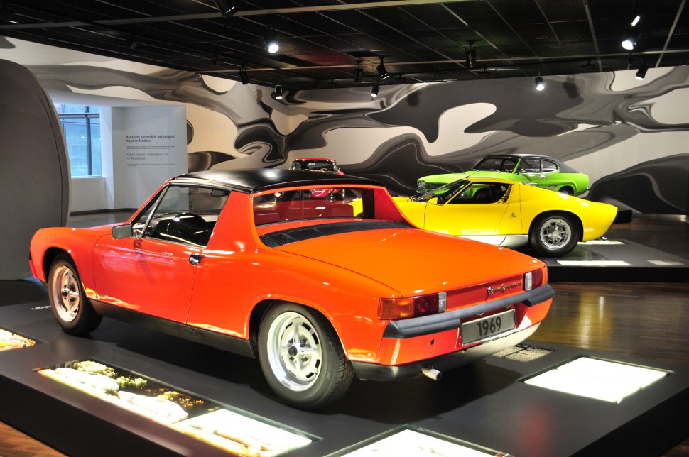 Rear view and side profile of a classic orange sports coupe