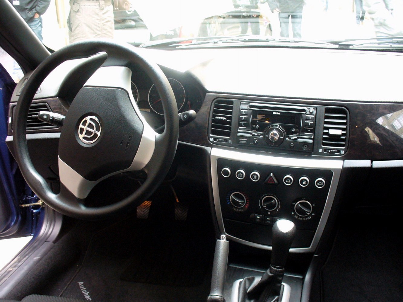 Car interior with dashboard, steering wheel, and manual gear shift