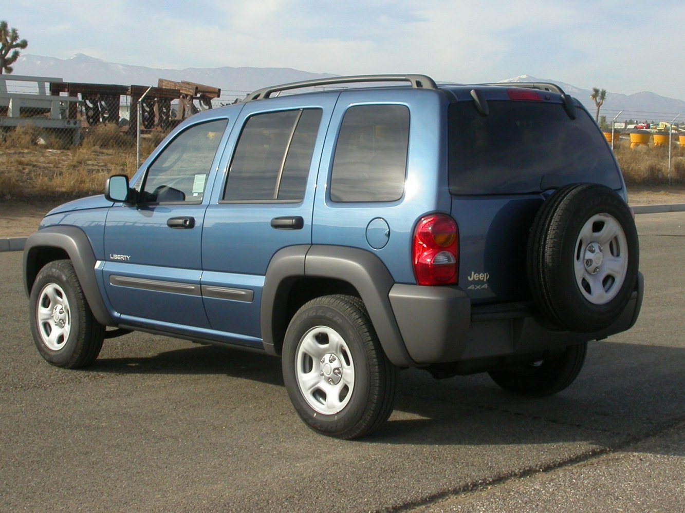 Rear side view of an SUV with mounted spare tire and tinted windows