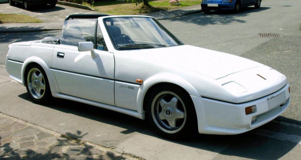 White convertible sports car with pop-up headlights and alloy wheels