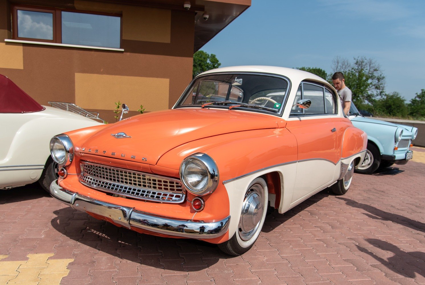 Two-tone vintage coupe with chrome grille and round headlights