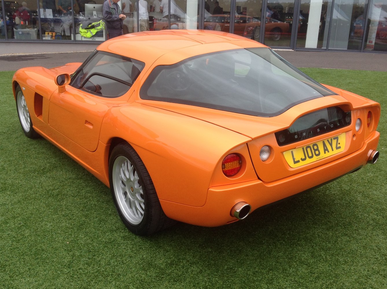 Rear and side view of a sleek sports coupe with round taillights and dual exhausts