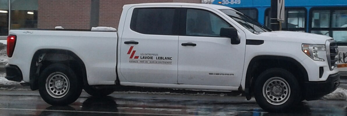 Side profile of white crew cab pickup with standard cargo box.