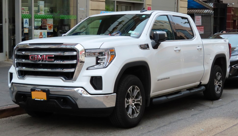 Front and side view of a white crew cab pickup with chrome grill and side steps