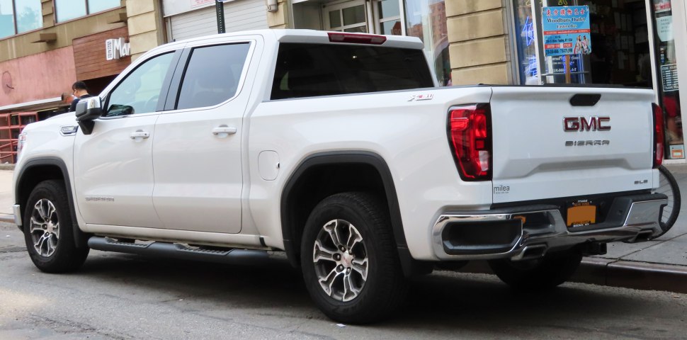 Rear view of a white crew cab pickup with detailed tailgate and wheels