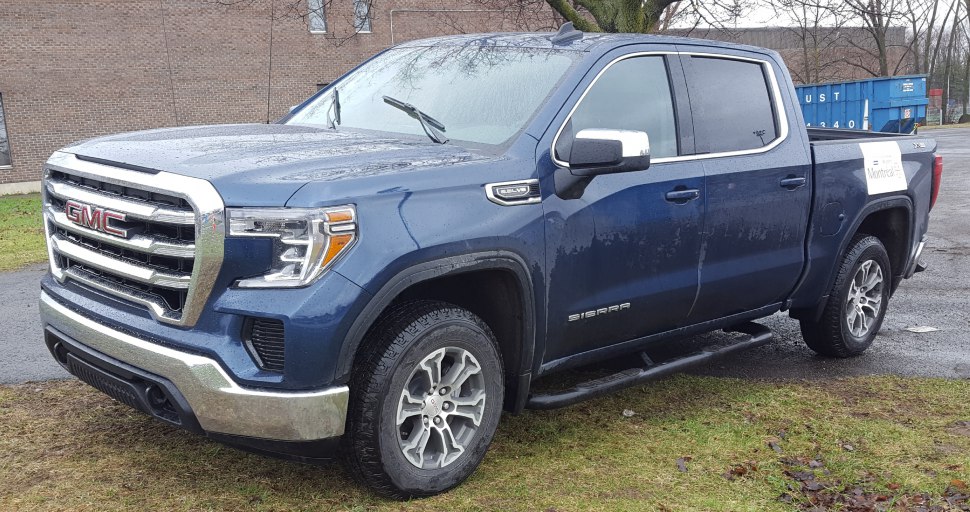 Front side view with chrome grille, alloy wheels, and side steps