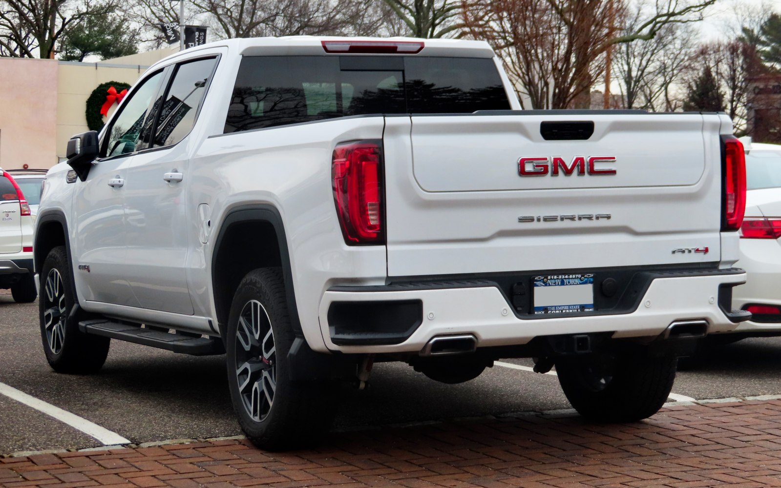 Rear view with tailgate, taillights, exhaust pipes, and crew cab short box design