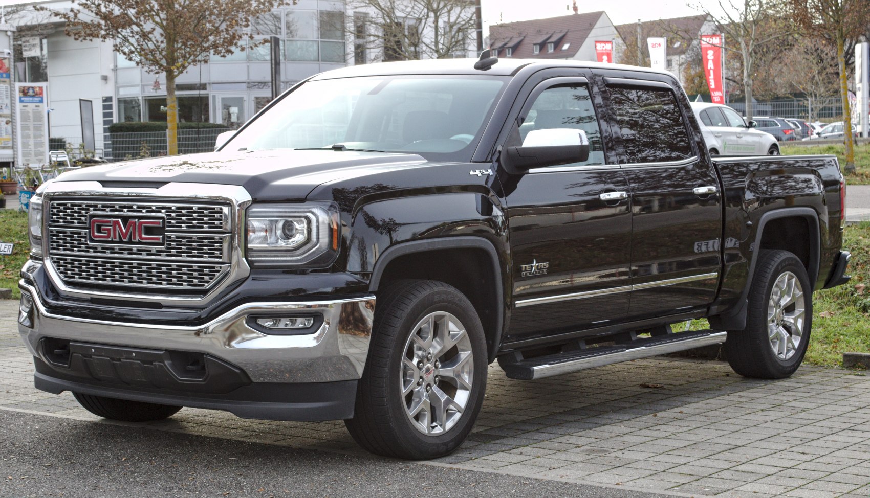 Front and side view of a black pickup with chrome grille and alloy wheels.