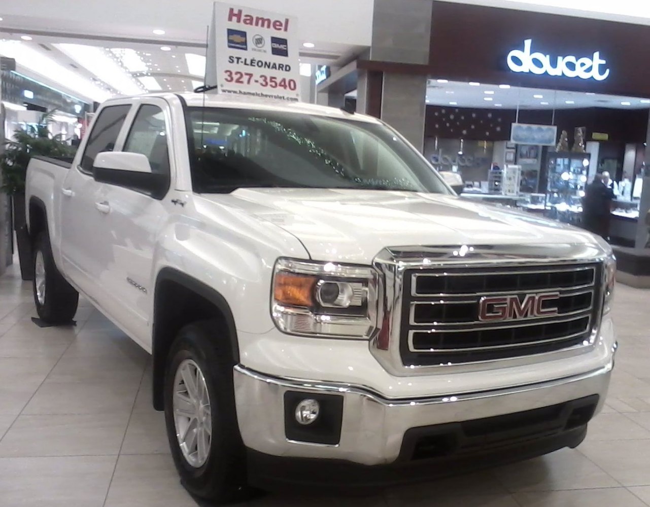 Front and side view of a white crew cab short box pickup