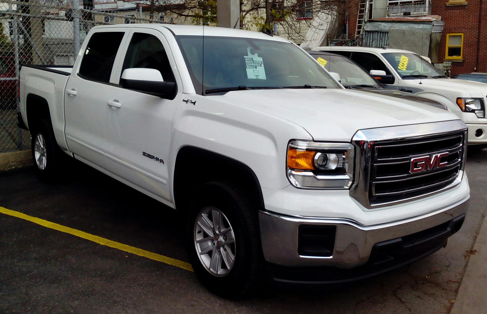 Front-side view of white pickup truck with crew cab and short box