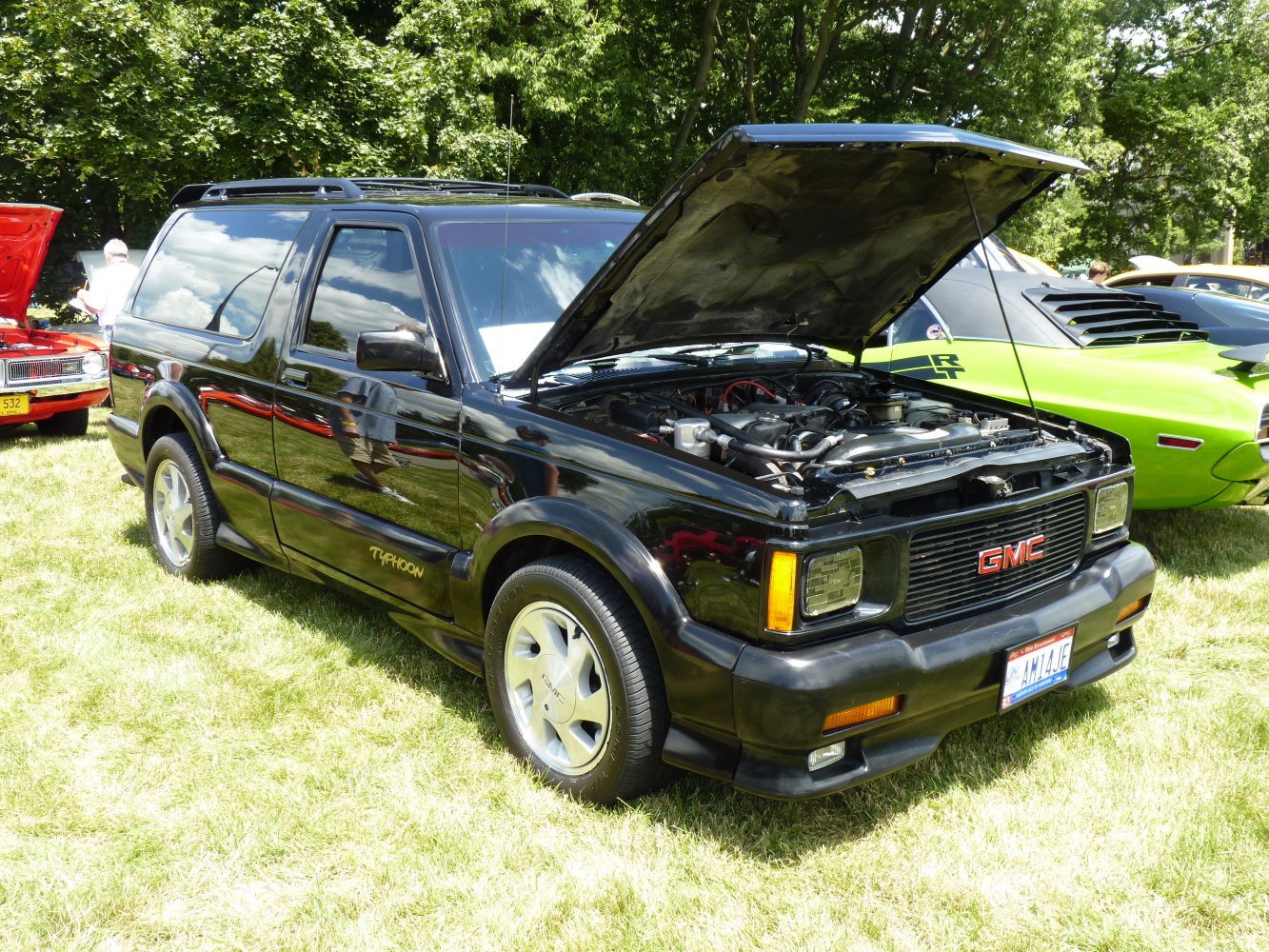 Black sporty SUV with open hood showing engine details.