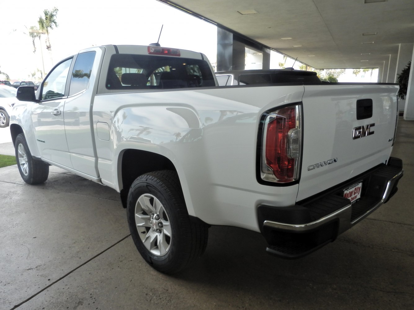 White extended cab pickup with long cargo bed and modern tail light