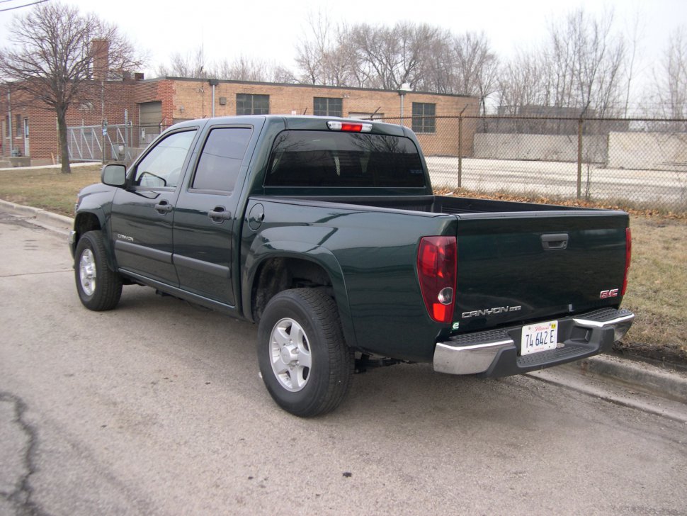 Rear side of a four-door pickup with open cargo bed and tinted windows