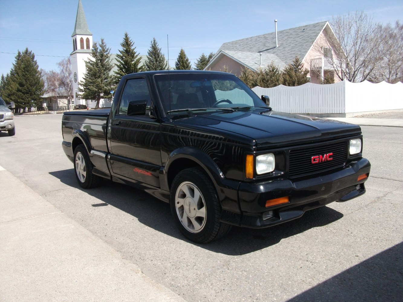 Black sporty pickup truck with compact body and distinctive front grille
