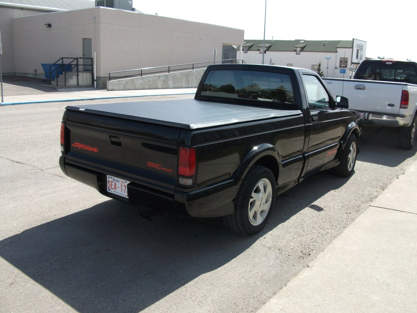 Rear angled view of pickup with flat tonneau cover and distinctive taillights